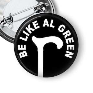 May include: A black and white button with the text "BE LIKE AL GREEN" in a circle around a white silhouette of a walking stick.