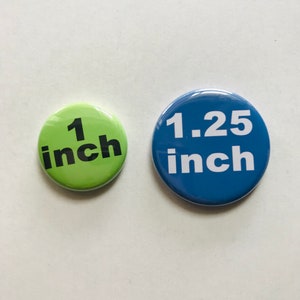 Peut inclure: Deux boutons ronds, un vert et un bleu. Le bouton vert indique "1 pouce" en texte noir. Le bouton bleu indique "1,25 pouce" en texte blanc.