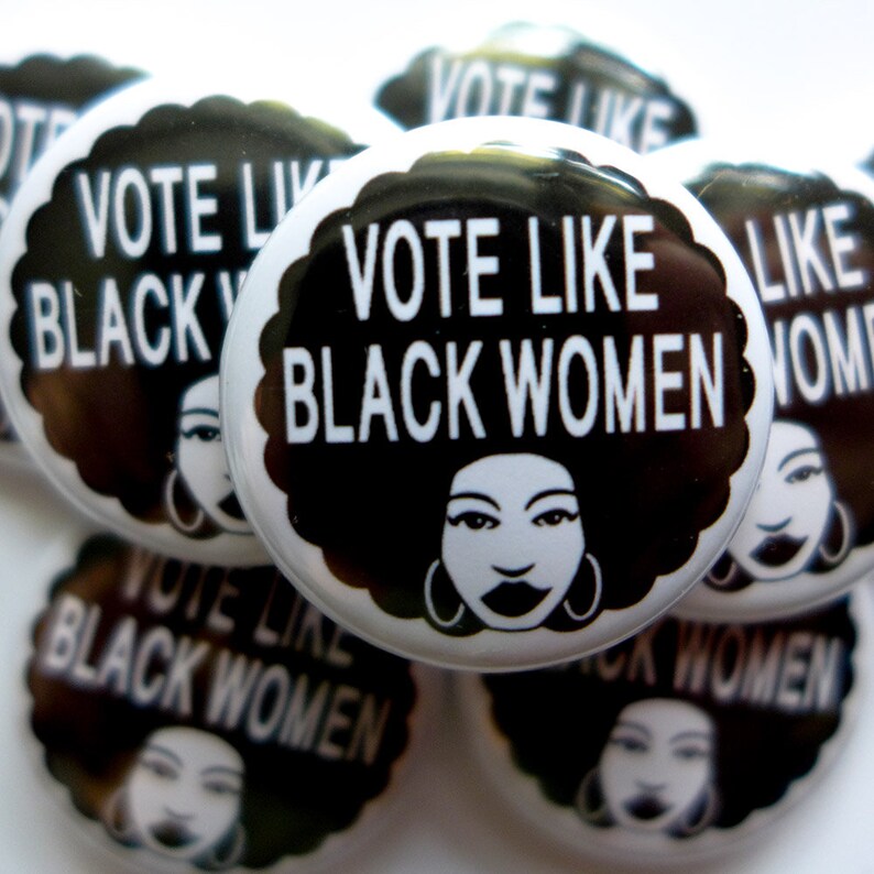Peut inclure: Un ensemble de badges en noir et blanc avec le texte "Vote Like Black Women" et une illustration stylis&eacute;e d'une femme noire avec une afro.