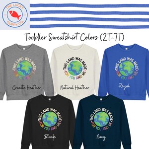 K&ouml;nnte beinhalten: Eine Auswahl an Sweatshirts f&uuml;r Kleinkinder in den Farben Grau, Creme, K&ouml;nigsblau, Schwarz und Marine. Jedes Sweatshirt zeigt eine Grafik der Erde mit dem Text "This land was made for you and me."