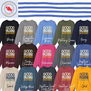 May include: A collection of sweatshirts in various colors, each displaying the text "GOOD TROUBLE" in a bold, white font. Colors include black, navy, and Carolina blue. The Lucky Guppy Co. logo is in the upper left corner.