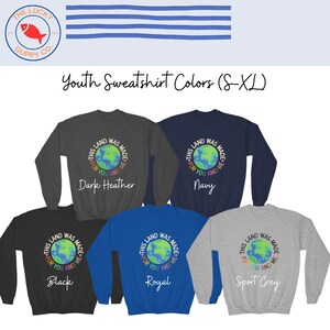 K&ouml;nnte beinhalten: Eine Auswahl an Sweatshirts f&uuml;r Jugendliche in verschiedenen Farben, darunter Dunkelgrau, Marineblau, Schwarz, K&ouml;nigsblau und Sportgrau. Jedes Sweatshirt zeigt eine Grafik der Erde mit dem Text "This land was made for you and me."