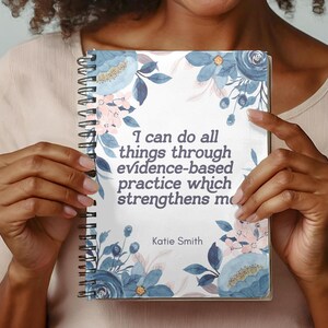 May include: A spiral bound journal with a floral design featuring blue and pink flowers. The journal has the quote "I can do all things through evidence-based practice which strengthens me" and the name "Katie Smith" printed on the cover.