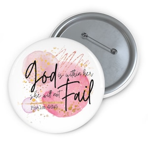 May include: A white button with a pink and gold watercolor design. The text "God is within her she will not fail Psalm 46:5" is written in black.