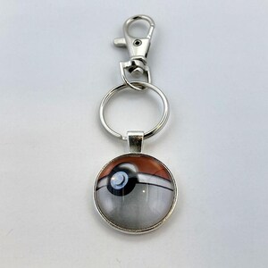 a metal keychain with a picture of a bird on it