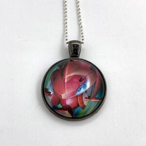 May include: A silver chain necklace with a round glass pendant featuring a red and blue robot illustration.