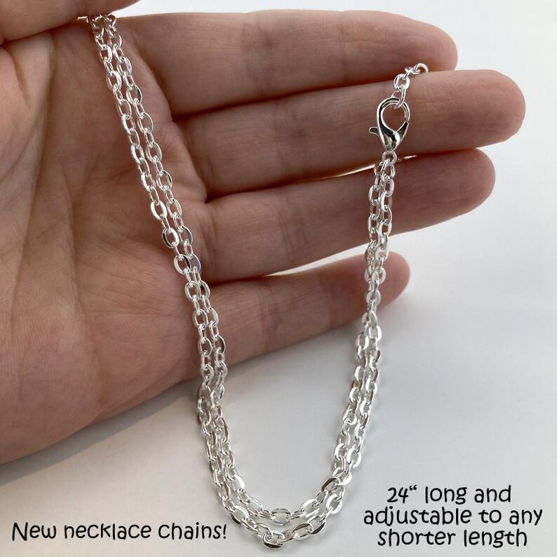 a hand holding a silver chain on a white background