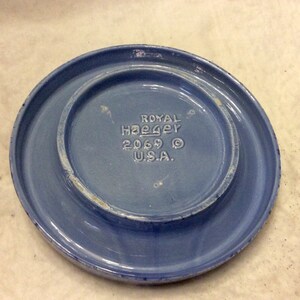 May include: A light blue ceramic plate with the text "ROYAL HAeger 2069 &copy; U.S.A." printed on the bottom.