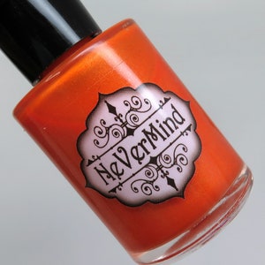 May include: A small orange bottle of nail polish with a black cap. The bottle has a label with the words "NeverMind" in a decorative font.