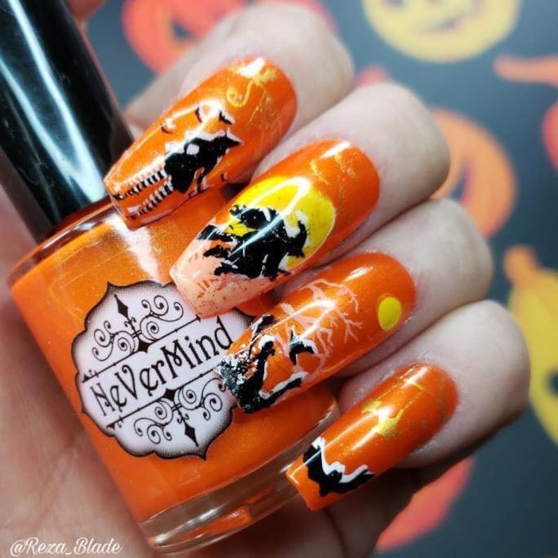 May include: Orange nail polish bottle with a white label that says "NeverMind".  The bottle is next to a hand with orange nail polish and Halloween-themed nail art featuring black silhouettes of bats, trees, and a full moon.