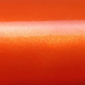 May include: A close-up of a bright orange surface with a subtle shimmer. The surface has a slightly textured appearance, giving it a metallic look.