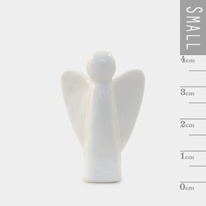 Puede incluir: Peque&ntilde;a figura de &aacute;ngel de cer&aacute;mica blanca. El &aacute;ngel tiene alas extendidas y un dise&ntilde;o simple y liso. La figura mide aproximadamente 4 cm de alto.