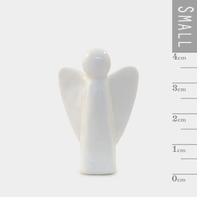 Puede incluir: Peque&ntilde;a figura de &aacute;ngel de cer&aacute;mica blanca. El &aacute;ngel tiene alas extendidas y un dise&ntilde;o simple y liso. La figura mide aproximadamente 4 cm de alto.