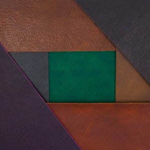 May include: A close-up of five different colored leather swatches. The swatches are arranged in a geometric pattern, with a green swatch in the center.