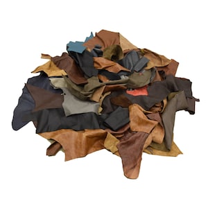 May include: A pile of assorted leather scraps in various shades of brown, tan, gray, and blue. The leather pieces are arranged in a random, overlapping pattern.