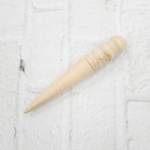 May include: A wooden leather stitching tool with a rounded tip and a textured handle.