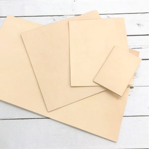 May include: Four pieces of beige leather in different sizes, stacked on top of each other. The leather is smooth and has a natural, slightly textured surface.