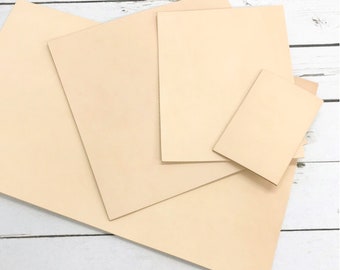 May include: Four pieces of beige leather in different sizes, stacked on top of each other. The leather is smooth and has a natural, slightly textured surface.