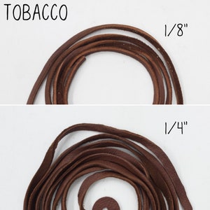 May include: Two brown leather cords, one 1/8 inch thick and the other 1/4 inch thick. The cords are coiled and laid out on a white surface.