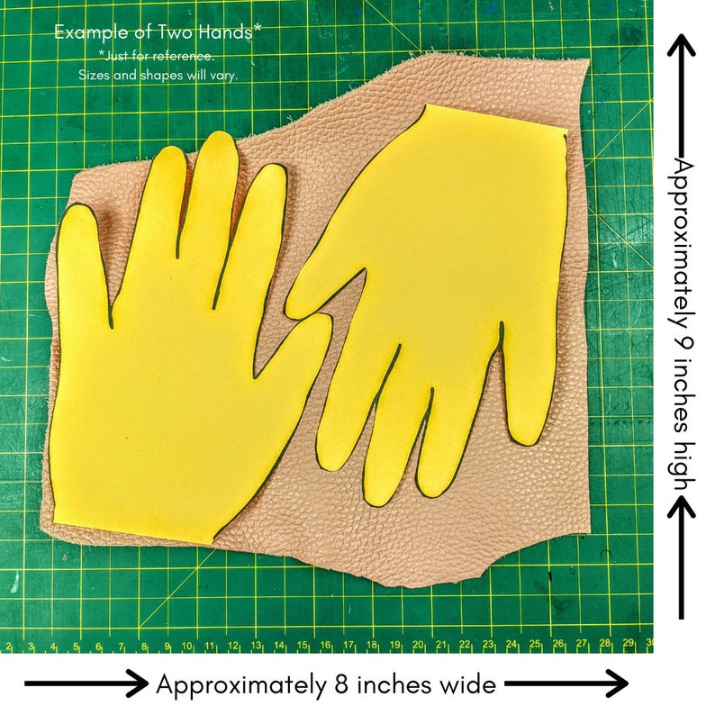 May include: Two yellow hand-shaped cutouts on a brown leather piece, placed on a green cutting mat with inch markings. The leather piece is approximately 9 inches high and 8 inches wide.