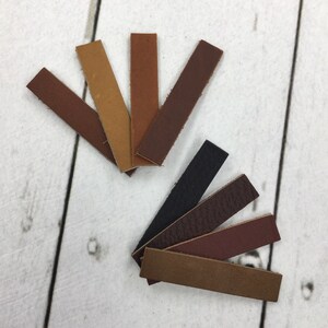 May include: Assortment of leather strips in various shades of brown, including dark brown, light brown, and tan. There is also a black leather strip and a dark red leather strip.