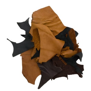 May include: A pile of leather scraps in various shades of brown and black. The pieces vary in shape and size, with some having jagged edges. The leather appears to have a textured surface, suggesting it may be suitable for crafting or other projects.