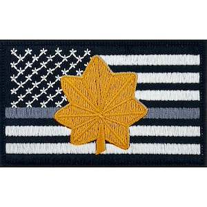 May include: A black and white American flag patch with a thin gray stripe across the middle. A gold embroidered five-pointed star is centered on the flag.