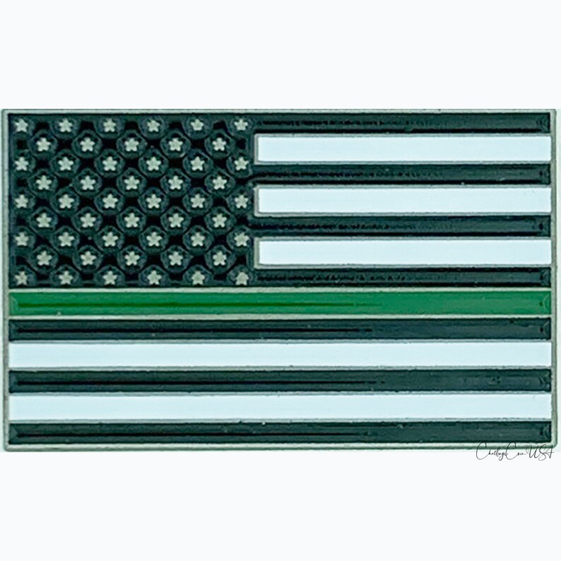 Pode incluir: Uma bandeira americana preta e branca com uma faixa verde no meio. A bandeira &eacute; feita de metal e tem um acabamento brilhante.