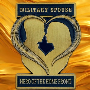 May include: Gold-colored metal pin with a blue enamel heart featuring two silhouettes facing each other. The text "MILITARY SPOUSE" is above the heart and "HERO OF THE HOME FRONT" is below the heart.