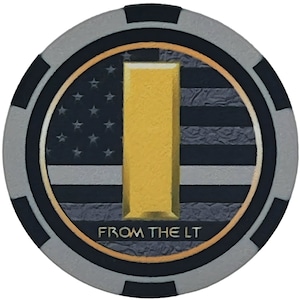 May include: A round, gray, black, and gold poker chip with a stylized American flag design. The chip features a gold letter "I" and the text "FROM THE LT". The outer edge is gray with black accents.