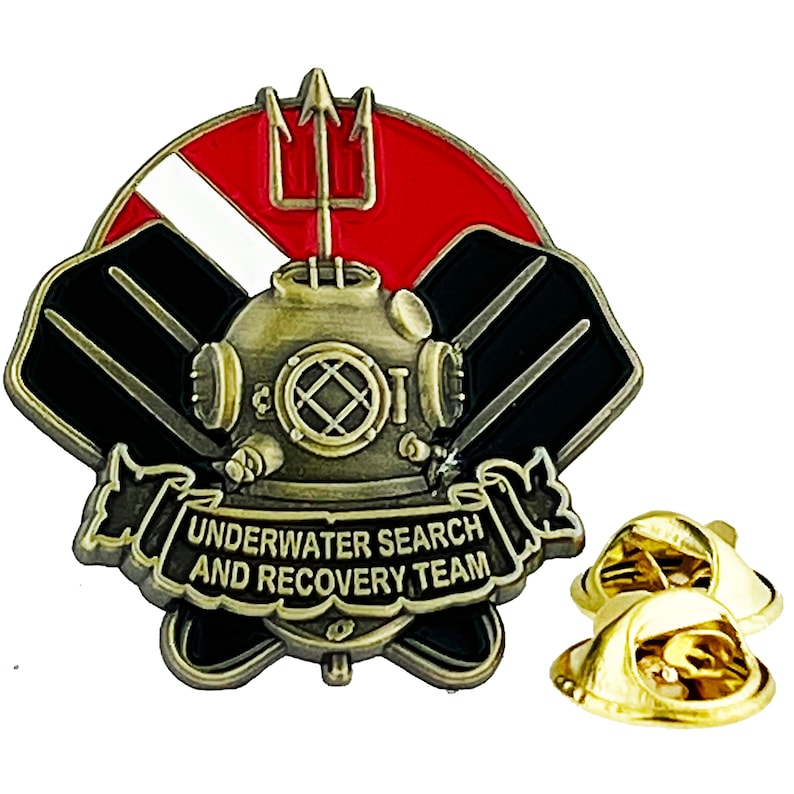 May include: A gold-toned metal pin with a diving helmet, a trident, and a scuba flag. The pin has a banner that reads "Underwater Search and Recovery Team".