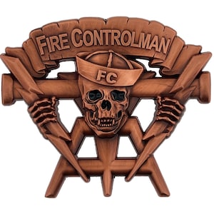 May include: A bronze-colored metal pin with a skull wearing a sailor hat with the letters "FC" on it. The skull is holding two lightning bolts. A banner above the skull reads "FIRE CONTROLMAN".