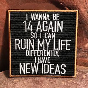 Puede incluir: Un tablero de letras de fieltro negro con un borde dorado, que muestra el texto "I WANNA BE 14 AGAIN SO I CAN RUIN MY LIFE DIFFERENTLY, I HAVE NEW IDEAS".