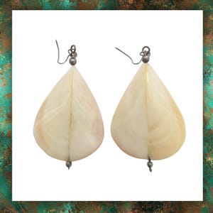 May include: A pair of teardrop-shaped earrings made of white mother of pearl with silver accents.