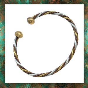 May include: A twisted silver, copper and gold bangle bracelet with rounded ends.