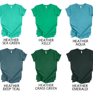 May include: Six heather t-shirts in various colors: sea green, kelly, aqua, deep teal, grass green, and emerald. Each shirt has a crew neck and short sleeves. The color names are printed below each shirt.