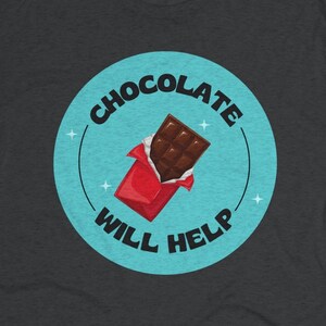 May include: Dark heather grey t-shirt with a blue circle graphic featuring a chocolate bar in a red wrapper and the text "CHOCOLATE WILL HELP".