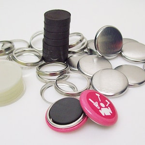 May include: Assortment of button making supplies including silver metal button backs, clear plastic button fronts, silver metal button rings, and black magnetic button backs.