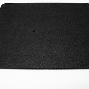 May include: A black rectangular piece of foam with four holes drilled into it.
