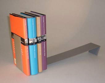 Op de afbeelding: Een set van vijf boeken met kleurrijke omslagen en zwart-witfoto's op de ruggen. De boeken worden rechtop gehouden door een zilveren metalen boekenlegger.