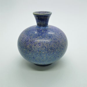 May include: A small, round, blue and purple ceramic vase with a speckled glaze.