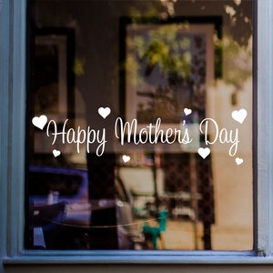 May include: White vinyl decal with the text "Happy Mother's Day" and small hearts surrounding the text. The decal is applied to a glass window.