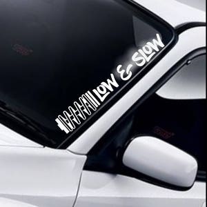 May include: White vinyl decal sticker for a car window. The sticker says "Go Slow & Low" with a graphic of a car suspension.