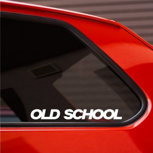 May include: A red car with a black window and a white vinyl sticker that says "OLD SCHOOL" on the rear window.