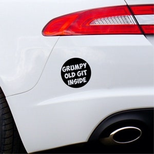 May include: A white car with a black circle sticker that says "Grumpy Old Git Inside".