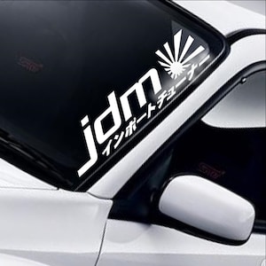 May include: White vinyl decal with the text "jdm" and Japanese characters that translate to "Import Tuner". The decal features a stylised rising sun graphic.