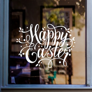 May include: White vinyl decal with the text "Happy Easter" in a decorative script font. The decal is placed on a glass window with a blurry background.