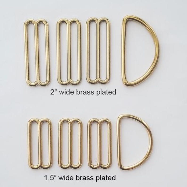 May include: Two sets of brass plated hardware, each containing three rectangular sliders and one D-ring. The top set is labelled 2 inches wide, and the bottom set is labelled 1.5 inches wide. These metal components are arranged in two horizontal rows.