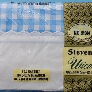 May include: A white full flat sheet with a blue and white gingham pattern and a white lace trim. The sheet is packaged in plastic and has a label that reads "Stevens Utica Percale - 50% Cotton - 50% Polyester" and "No Iron Stay Neat and Smooth". The label also states that the sheet is for a 54 x 75 inch mattress (81 x 104 inches before hemming).