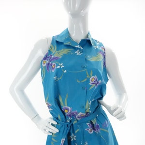 May include: A sleeveless blue floral print jumpsuit with a collared button-up top and a matching tie belt.